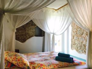 a bedroom with a bed with curtains and a window at Angeli di Montefiore in Montefiore dellʼAso +22 photos
