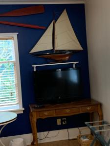a tv with a model of a boat on a wall at Katys Inn in La Conner