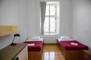2 letti in una piccola camera con finestra di The Grey Nuns Residence by Concordia University a Montréal