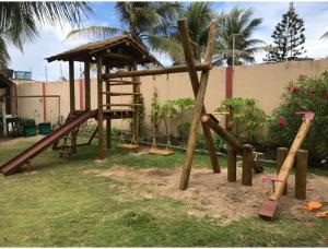 un parque infantil con tobogán y columpio en Chalé em frente à Praia en Salvador