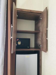 Habitación con TV y estante con microondas. en Hotel Tourist en Tiflis