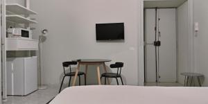 La stanza di Camillo في روما: غرفة مع طاولة وكراسي وتلفزيون على الحائط