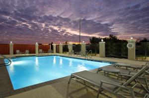 a large swimming pool with chairs at Holiday Inn Express & Suites - Brookshire - Katy Freeway, an IHG Hotel in Brookshire
