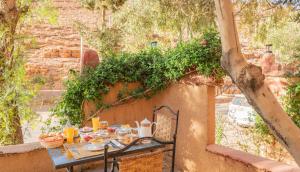 a table with food on it next to a wall at Riad Kasbah des Roches in Akhendachou nʼAït Ouffi