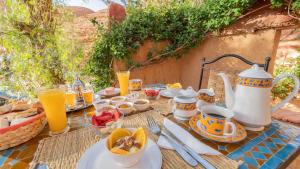 einen Tisch mit Frühstückslebensmittel und Orangensaft darauf in der Unterkunft Riad Kasbah des Roches in Akhendachou nʼAït Ouffi