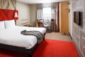 ノーサンプトンにあるイビス ホテル ノーサンプトン センターの赤いカーペット敷きの客室で、ベッド1台が備わります。