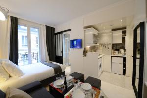 Résidence Voûte في باريس: غرفه فندقيه بسرير ومطبخ