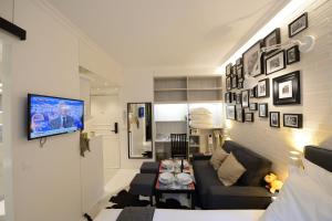 uma sala de estar com um sofá e uma televisão na parede em Résidence Voûte em Paris