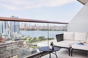 a balcony with a couch and a view of a city at The William Vale in Brooklyn