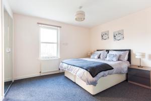 a white bedroom with a bed and a window at City View in Aberdeen