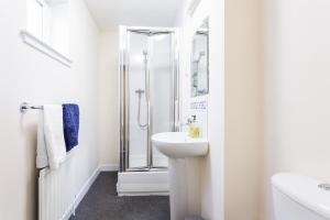 baño blanco con ducha y lavamanos en City View, en Aberdeen