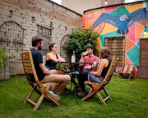 un grupo de personas sentadas alrededor de una mesa en un patio en Hostel Running Chaski, en Cochabamba