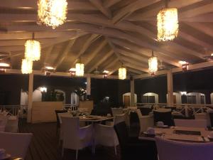 a dining room with tables and chairs and chandeliers at The blue lagoon of the Caribbean Sea. Velero 205.Cadaques Caribe in La Fragata