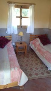 a bedroom with two beds and a table with a lamp at auberge souktana in Taliouine