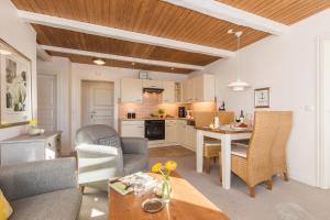 a kitchen and living room with a table and chairs at Ferienhof Kähler in Fehmarn