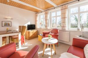 フェーマルンにあるFerienhof Kählerのリビングルーム(赤い椅子、テーブル付)