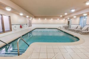 a pool in a hotel room with chairs and a pool at Holiday Inn Express Hotel & Suites Bethlehem, an IHG Hotel in Bethlehem