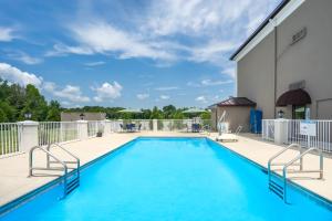a swimming pool on a patio with a building at Holiday Inn Express Hotel & Suites Fort Payne, an IHG Hotel in Fort Payne