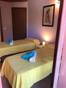 a room with three beds in a room with a candle at Panorama Penthouse con giardino privato in Santadi