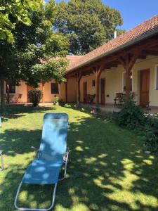 a blue lawn chair in the yard of a house at Tisza-Kert Vendégház -Tisza-Kert Vendégház II in Tiszafüred