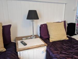 
a bed with pillows and a lamp on top of it at Aqua Bay Guest House in Herne Bay
