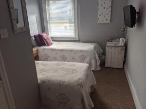 a small room with two beds and a window at Aqua Bay Guest House in Herne Bay