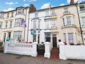 un edificio blanco con una bandera delante de él en Aqua Bay Guest House, en Herne Bay