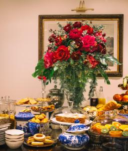 una mesa con un jarrón lleno de rosas rojas en Hotel Jolanda, en Santa Margherita Ligure