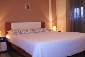 a bedroom with a white bed and a window at Apartments Silvana sunset view in Zadar