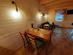 a wooden dining room with a table and chairs at Chaty Mazur w Wierzbie in Ruciane-Nida