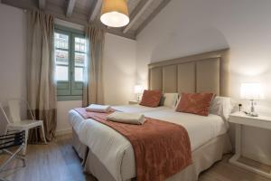 Un dormitorio con una cama grande y una ventana en Palacio Cabrera - Lillo, en Granada