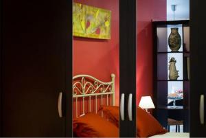 セビリアにあるApartamento Azaharの赤い壁のベッドルーム1室(ベッド1台付)