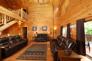 a living room with leather furniture in a cabin at Majestic Manor Cabin in Waldens Creek