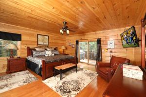 a bedroom with a bed in a room with wooden walls at Majestic Manor Cabin in Waldens Creek