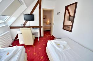 a hotel room with two beds and a desk at Hotel Alt-Connewitz in Leipzig