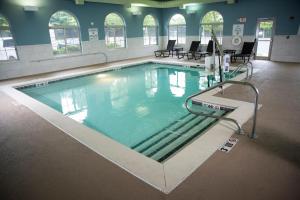 a swimming pool in a gym with chairs and tables at Holiday Inn Express Hotel & Suites Lexington-Downtown University, an IHG Hotel in Lexington