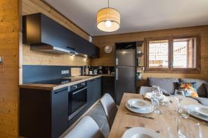 uma cozinha com uma mesa de madeira e uma sala de jantar em ODYSSEE CRC01 Appartement traversant sur les pistes em La Toussuire