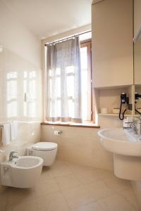 a bathroom with a sink and a toilet and a window at Borromeo Rooms Bed & Living in Vimercate