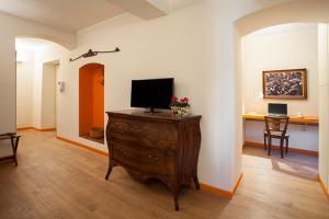 a living room with a tv on a wooden dresser at Borromeo Rooms Bed & Living in Vimercate