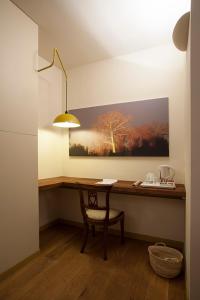 a desk with a chair and a painting on the wall at Borromeo Rooms Bed & Living in Vimercate