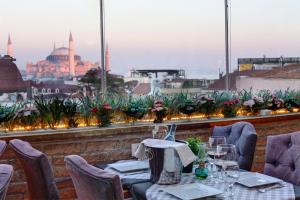 a dining room table with a balcony overlooking a city at Great Fortune Hotel & Spa in Istanbul