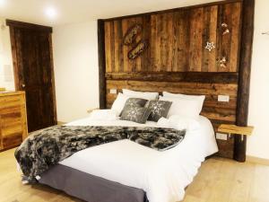 een slaapkamer met een groot bed en een houten muur bij Domus Apartments in Aosta