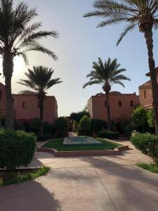 a group of palm trees in a courtyard at Villa avec piscine a Marrakech in Marrakesh