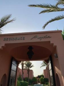 an entrance to a restaurant with palm trees and a building at Villa avec piscine a Marrakech in Marrakesh