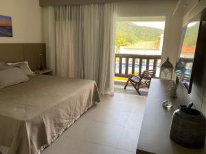a bedroom with a bed and a view of a balcony at Buzios Beach Resort Super Luxo Residencial 2501 e 2502 in Búzios +61 photos