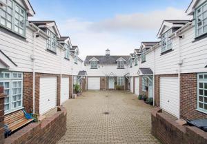 una fila de casas con puertas blancas y un patio en Bo's Holiday Cottage, en Eastbourne