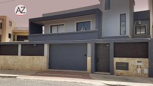 a building with two garage doors in front of it at YOUR HOME AWAY FROM HOME in Praia