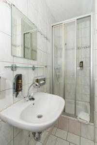 a white bathroom with a sink and a shower at Waldhaus Altenbrak in Altenbrak