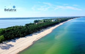 uma vista aérea de uma praia com árvores e água em Belatrix nad Bałtykiem em Mielno