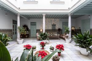 ein Wohnzimmer mit Pflanzen und Blumen auf einer Terrasse in der Unterkunft Palacio Cabrera - Lillo in Granada